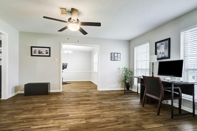 office area with plenty of natural light, wood finished floors, visible vents, and baseboards