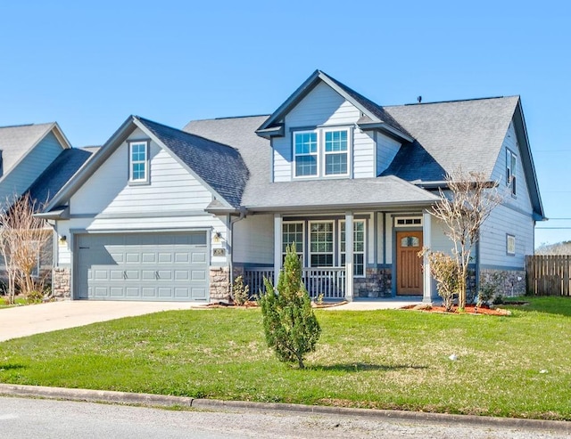 craftsman house featuring a porch, stone siding, driveway, and a front lawn