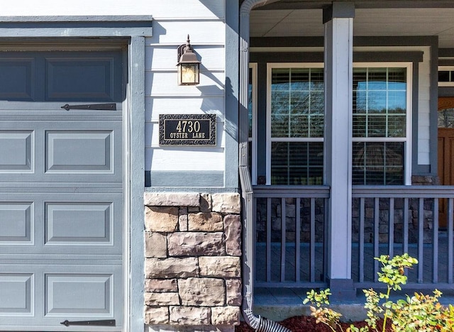 entrance to property featuring a porch and a garage