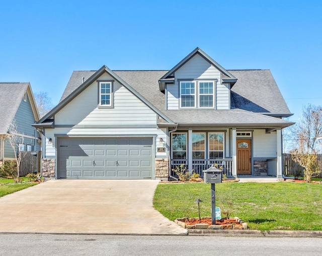 craftsman house featuring stone siding, concrete driveway, a front lawn, and a shingled roof