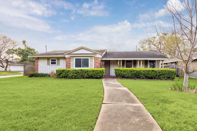 view of front of home with board and batten siding, a front yard, fence, and brick siding