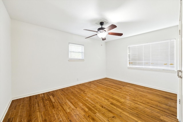 spare room featuring wood finished floors, baseboards, and ceiling fan