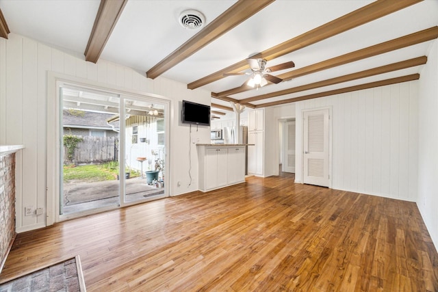 unfurnished living room featuring beam ceiling, light wood-style flooring, visible vents, and ceiling fan