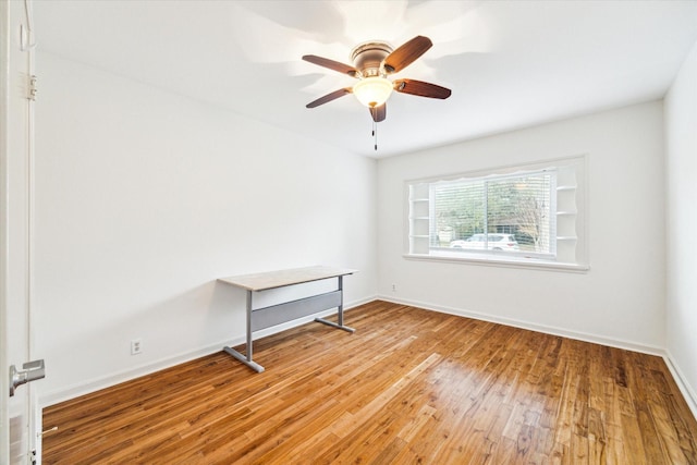 empty room featuring light wood finished floors, ceiling fan, and baseboards