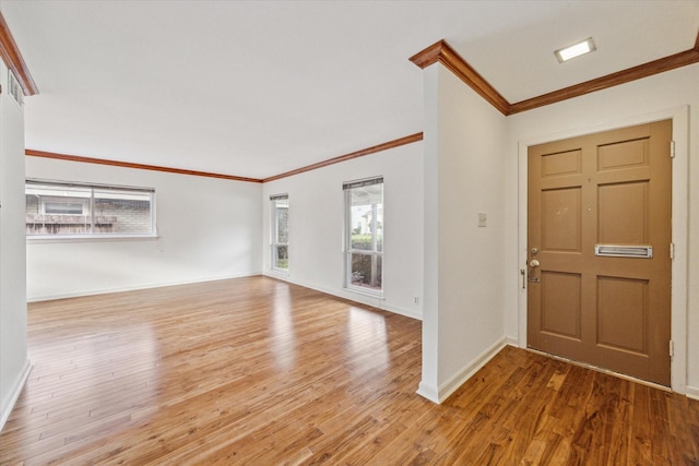 foyer entrance with crown molding, baseboards, and wood finished floors