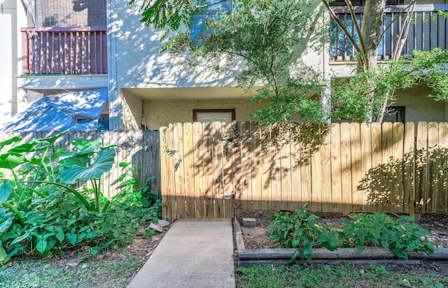 exterior space featuring stucco siding and fence