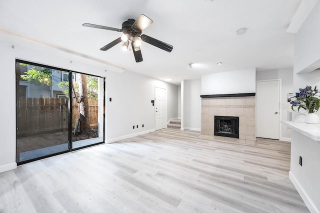 unfurnished living room featuring baseboards, a fireplace, and light wood finished floors