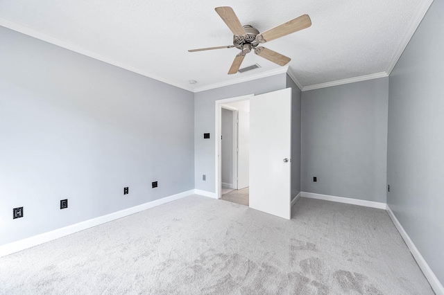 unfurnished bedroom with visible vents, light carpet, baseboards, and ornamental molding