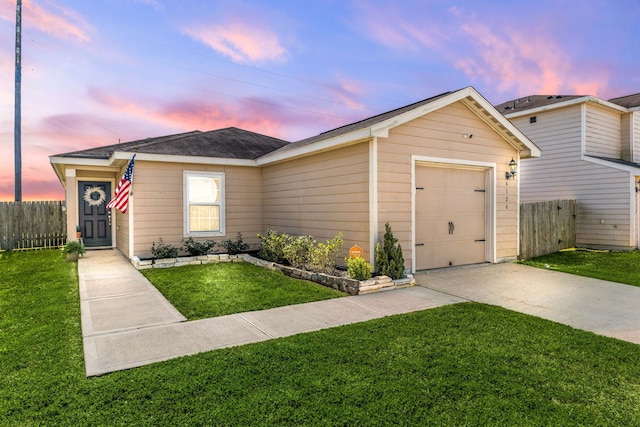 view of front of property featuring a front lawn, an attached garage, fence, and driveway