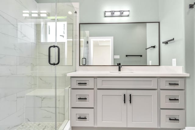 bathroom with vanity and a marble finish shower