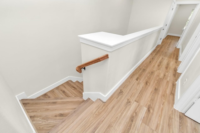 staircase with wood finished floors and baseboards