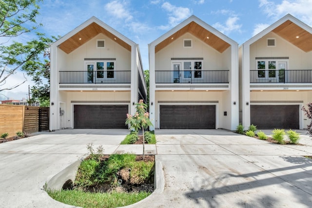 view of front of property with concrete driveway, an attached garage, and stucco siding