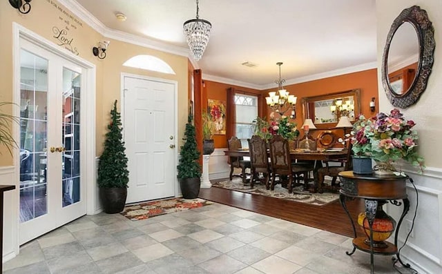 entryway featuring a notable chandelier, french doors, and ornamental molding