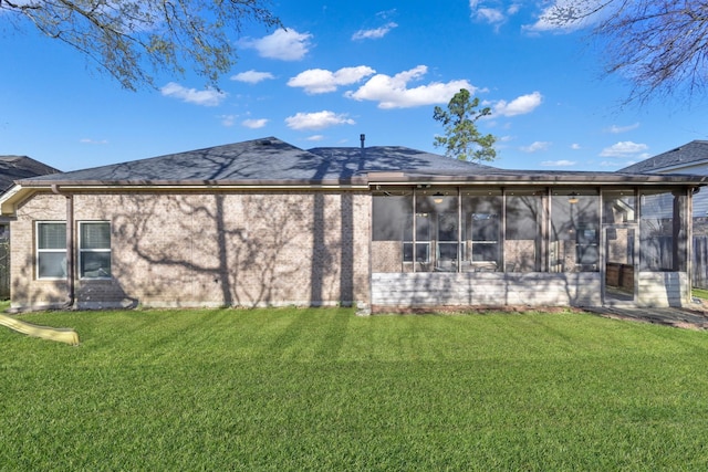 rear view of property featuring a yard and a sunroom