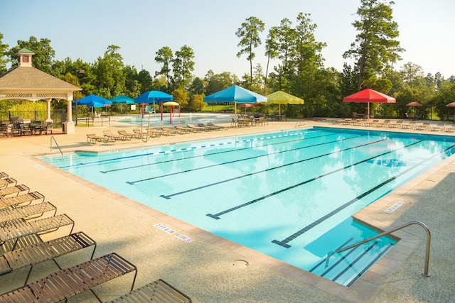 community pool featuring a gazebo, a patio, and fence