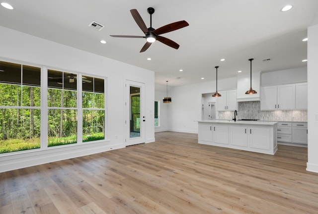 kitchen featuring visible vents, light wood finished floors, recessed lighting, decorative backsplash, and light countertops