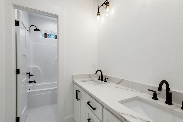 bathroom with double vanity, washtub / shower combination, and a sink