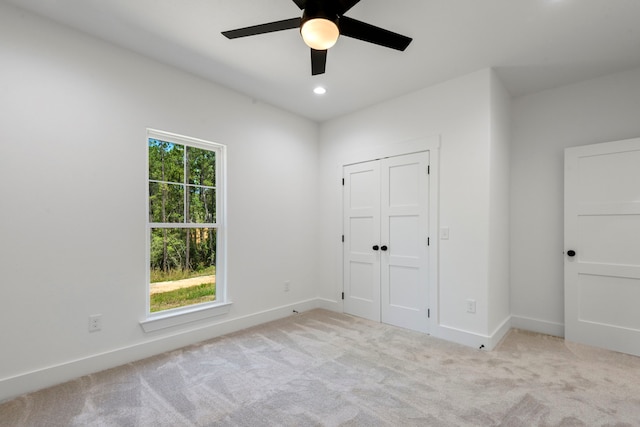 unfurnished bedroom featuring multiple windows, carpet floors, and baseboards