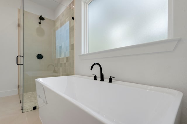 full bathroom featuring a freestanding bath, a shower stall, and tile patterned flooring