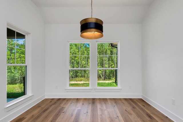 unfurnished dining area featuring hardwood / wood-style flooring and baseboards