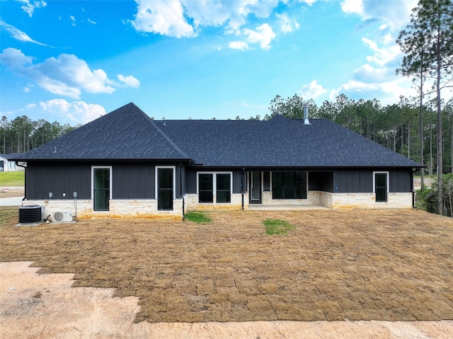 single story home featuring board and batten siding, stone siding, and roof with shingles