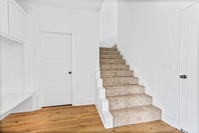 staircase with baseboards and wood finished floors