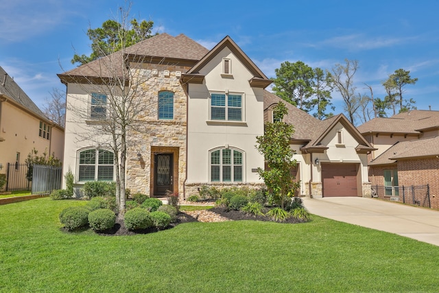 french country style house with stone siding, stucco siding, driveway, and fence