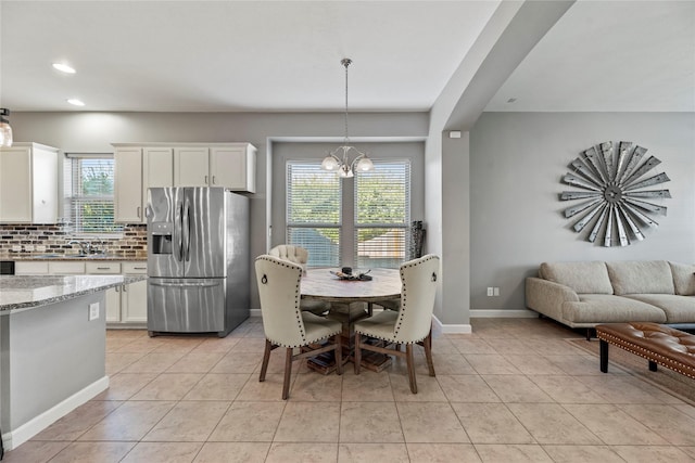 dining space with a chandelier, light tile patterned floors, recessed lighting, and baseboards