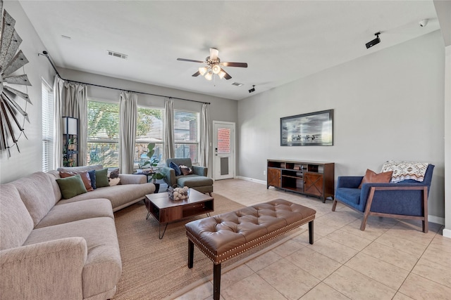 living area with light tile patterned flooring, visible vents, baseboards, and a ceiling fan