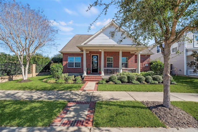 view of front facade featuring a porch, brick siding, and a front lawn