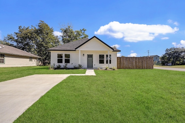 view of front of home with a front yard and fence