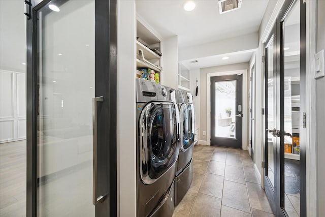 laundry room featuring washing machine and clothes dryer, visible vents, recessed lighting, and light tile patterned floors