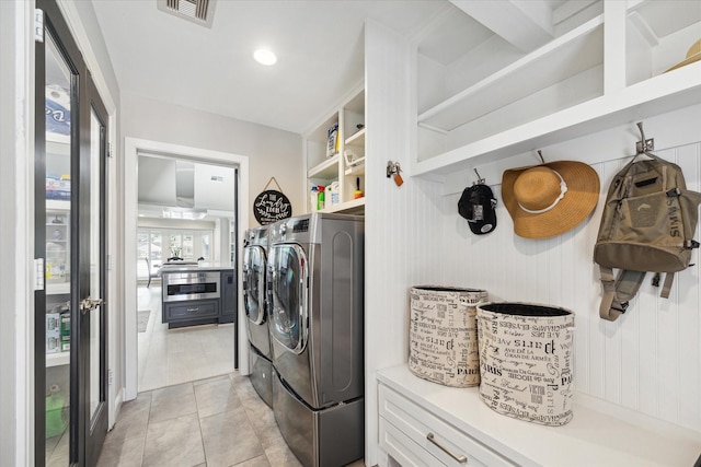 washroom with light tile patterned floors, laundry area, visible vents, and separate washer and dryer