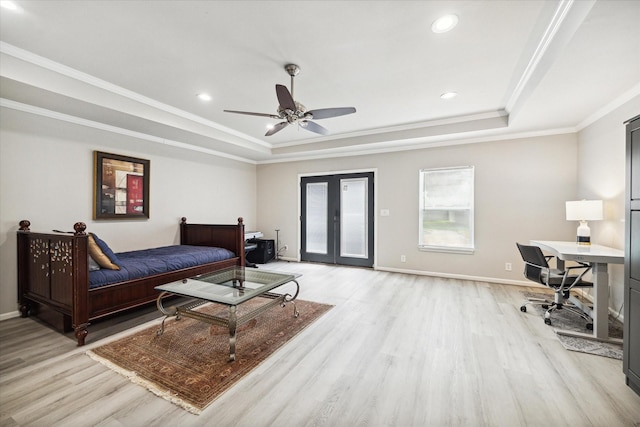 bedroom featuring a tray ceiling, access to outside, light wood-style flooring, and baseboards