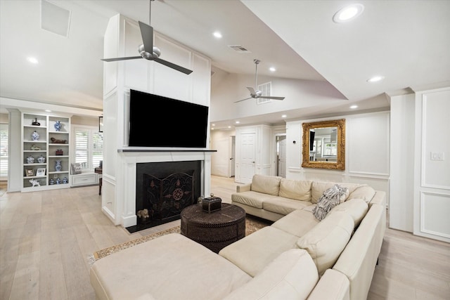 living room with recessed lighting, visible vents, a fireplace with flush hearth, and light wood-style floors