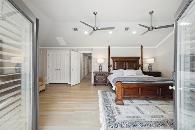 bedroom with lofted ceiling, visible vents, and light wood finished floors