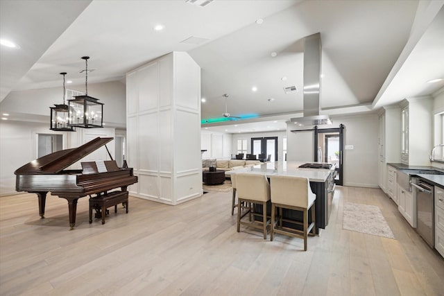 kitchen featuring open floor plan, light wood-style flooring, island exhaust hood, a large island, and white cabinetry