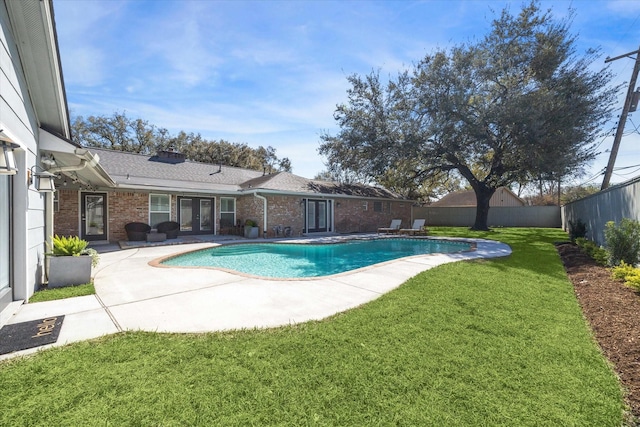 view of pool featuring a patio, a fenced in pool, a yard, a fenced backyard, and french doors