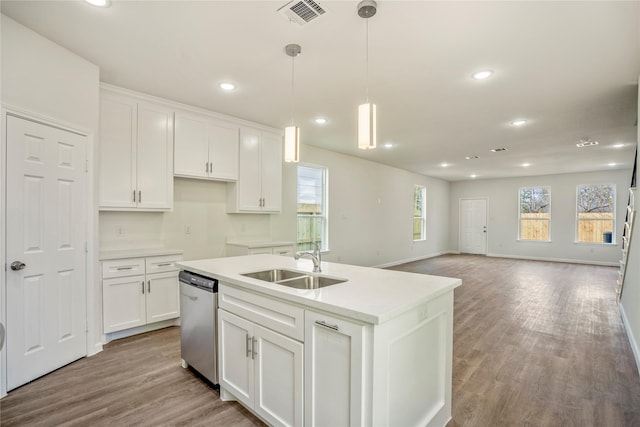 kitchen featuring dishwasher, wood finished floors, white cabinetry, and a sink