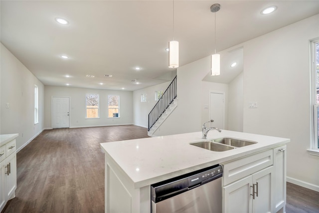 kitchen featuring stainless steel dishwasher, dark wood-type flooring, light countertops, and a sink