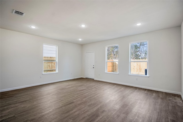 spare room with recessed lighting, visible vents, baseboards, and dark wood finished floors