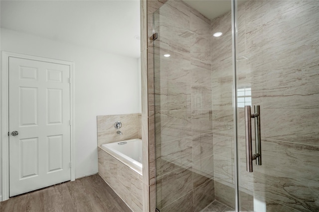 full bath featuring a marble finish shower, wood finished floors, and a bath