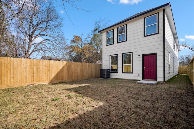 back of house with cooling unit, a lawn, and a fenced backyard