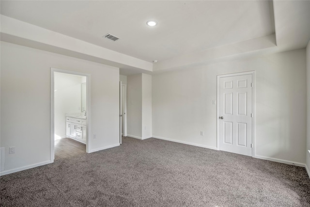 unfurnished bedroom with visible vents, recessed lighting, baseboards, carpet floors, and a raised ceiling