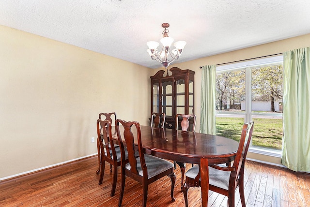 19331 E Lakeshore Dr, Magnolia, TX 77355 - dining room with hardwood / wood-style flooring, a chandelier, a textured ceiling, and baseboards