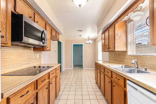 19331 E Lakeshore Dr, Magnolia, TX 77355 - kitchen with stainless steel microwave, dishwasher, black electric cooktop, a sink, and light countertops