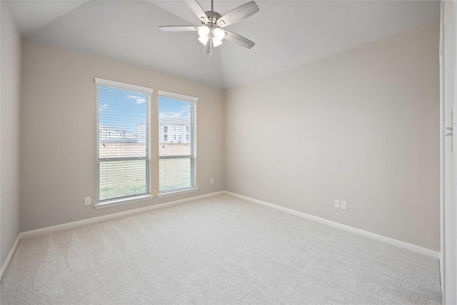 empty room with lofted ceiling, a ceiling fan, baseboards, and carpet floors