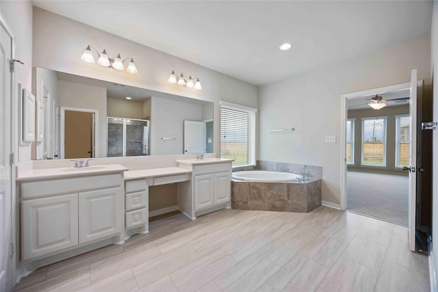 bathroom featuring a wealth of natural light, vanity, a garden tub, and a shower stall