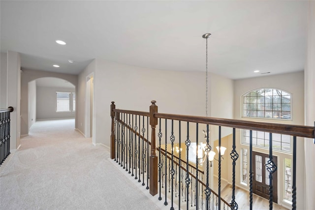 hallway featuring recessed lighting, an upstairs landing, and arched walkways