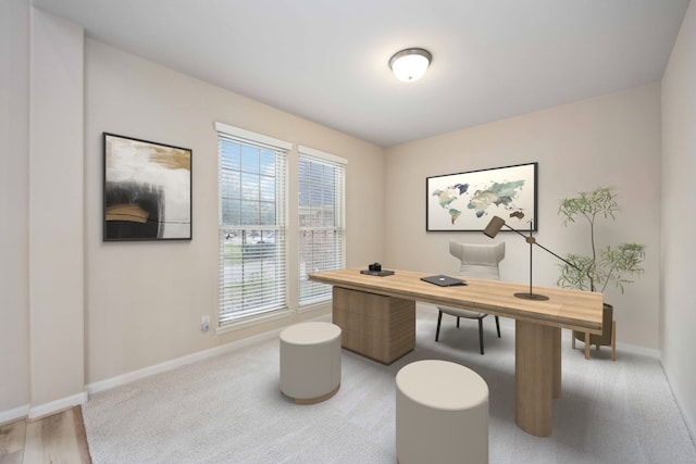 office with baseboards and light carpet